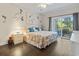 Bright bedroom with queen size bed, ceiling fan, hardwood floors, and private balcony access at 1100 Commons Blvd. # 104, Myrtle Beach, SC 29572