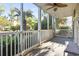 Covered porch with ceiling fan, white railings, and views of landscaped greenery at 1100 Commons Blvd. # 104, Myrtle Beach, SC 29572