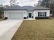 Charming single-Gathering home featuring white siding, a two-car garage, and a well-maintained lawn at 348 Jay St., Murrells Inlet, SC 29576