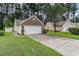 Home's brick-accented two-car garage and driveway nestled among green lawns and shade trees at 376 Mckendree Ln., Myrtle Beach, SC 29579