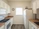 Efficient kitchen features white appliances and cabinets, light countertops and a window with natural light at 2060 Cross Gate Blvd. # 305, Surfside Beach, SC 29575