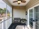 Screened-in patio features a ceiling fan, a small table, and a comfy bench, perfect for relaxation at 2060 Cross Gate Blvd. # 305, Surfside Beach, SC 29575