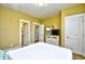 Comfortable bedroom featuring a white quilted bedspread, yellow walls, and a TV on a white dresser at 4808 Cantor Ct., North Myrtle Beach, SC 29582