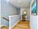 Upstairs hallway with hardwood floors, a desk area, and an elegant sunburst mirror at 4808 Cantor Ct., North Myrtle Beach, SC 29582