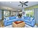 Cozy living room features comfortable blue couches, a ceiling fan, and plenty of natural light at 4808 Cantor Ct., North Myrtle Beach, SC 29582