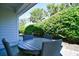 Covered patio seating area with a round table and chairs with natural landscaping at 4808 Cantor Ct., North Myrtle Beach, SC 29582