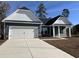 Charming one-story home featuring a two-car garage, stone accents, and a well-manicured lawn under a clear blue sky at 216 Palmetto Sand Loop, Conway, SC 29527