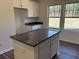 Kitchen island with granite countertop, white cabinets, and convenient electrical outlets providing ample space and functionality at 216 Palmetto Sand Loop, Conway, SC 29527