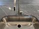 Close-up of a stainless steel sink with a brushed metal faucet and matching granite counter tops at 216 Palmetto Sand Loop, Conway, SC 29527