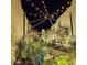 Charming patio illuminated with festive string lights and beautifully landscaped garden, perfect for evening relaxation at 216 Palmetto Sand Loop, Conway, SC 29527