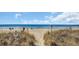 Path to a gorgeous sandy beach under a sunny blue sky with calm ocean waves at 212 2Nd Ave. N # 364, North Myrtle Beach, SC 29582