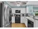 Well-lit kitchen features stainless steel refrigerator, white cabinets, and modern black appliances at 212 2Nd Ave. N # 364, North Myrtle Beach, SC 29582