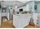 Kitchen with breakfast bar features stainless steel refrigerator, white cabinets, and modern appliances at 212 2Nd Ave. N # 364, North Myrtle Beach, SC 29582