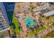 Aerial view of community pool with a winding slide, ample seating and palm tree landscaping at 3000 N Ocean Blvd. # 1601, Myrtle Beach, SC 29577