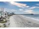 Expansive beach view showcasing the sandy shoreline, ocean, and nearby pier at 328 S Waccamaw Dr., Garden City Beach, SC 29576