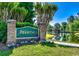 Inviting entrance sign for The Moorings, surrounded by colorful flowers and overlooking a tranquil pond at 4430 Turtle Ln. # 2-C, Little River, SC 29566