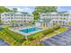Community pool with chairs and lounge area in a condominium complex with lush landscaping and parking lot at 4430 Turtle Ln. # 2-C, Little River, SC 29566