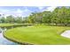 Scenic view of a well-manicured golf course with a pond and sand traps at 4430 Turtle Ln. # 2-C, Little River, SC 29566