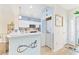 Coastal kitchen with white cabinets, tiled backsplash, breakfast bar, and adjacent laundry closet at 4430 Turtle Ln. # 2-C, Little River, SC 29566