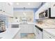 Bright kitchen with white countertops, stainless steel appliances, decorative accents, and breakfast bar to living area at 4430 Turtle Ln. # 2-C, Little River, SC 29566