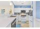 Well-lit kitchen featuring stainless steel appliances, white cabinetry, blue accent wall, and a breakfast bar at 4430 Turtle Ln. # 2-C, Little River, SC 29566
