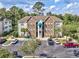 Attractive condo building with stone accents, a parking lot, and mature landscaping at 9772 Leyland Dr. # 9772-9, Myrtle Beach, SC 29572