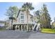 Stunning raised beach house featuring a spacious deck, palm trees and stairs leading to ground level at 5800 Creekside Dr., Myrtle Beach, SC 29588