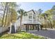 Striking elevated home featuring a modern design, complete with expansive decks and palm trees at 5800 Creekside Dr., Myrtle Beach, SC 29588