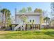 Charming home on stilts with dual staircases and large yard, complemented by tropical palm trees at 5800 Creekside Dr., Myrtle Beach, SC 29588
