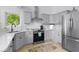 Well-lit kitchen with gray cabinets, stainless appliances, and view of exterior at 5800 Creekside Dr., Myrtle Beach, SC 29588