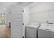 Well-lit laundry room with a washing machine, dryer, shelving, and door to living room at 5800 Creekside Dr., Myrtle Beach, SC 29588