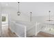 Loft area with white railings, modern light fixtures, and light wood flooring at 5800 Creekside Dr., Myrtle Beach, SC 29588
