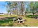 Landscaped yard featuring stone picnic table, surrounded by mature trees and flowering plants at 5800 Creekside Dr., Myrtle Beach, SC 29588