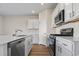 Bright kitchen featuring white cabinets, stainless steel appliances, and modern fixtures at 3046 Deerberry Place, Longs, SC 29568