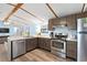 Well-lit kitchen with stainless appliances, wood cabinets, marble countertops, and open access to the living area at 6001-Mh107 S Kings Hwy., Myrtle Beach, SC 29575