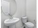 Powder room with pedestal sink, brushed nickel faucet, and oval mirror at 7004 Watercress St, Myrtle Beach, SC 29579