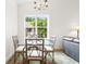 Charming dining area features a glass-top table, chandelier, and a bright window with views of the outdoors at 1137 Peace Pipe Ln. # 201, Myrtle Beach, SC 29579