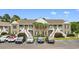 Inviting condo building exterior with lush landscaping, palm trees and ample parking at 1137 Peace Pipe Ln. # 201, Myrtle Beach, SC 29579