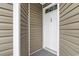 Front door of unit 201 with neutral-colored siding and dark welcome mat at 1137 Peace Pipe Ln. # 201, Myrtle Beach, SC 29579