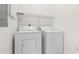 Laundry area with a white washer and dryer, and wire shelving above at 1137 Peace Pipe Ln. # 201, Myrtle Beach, SC 29579