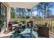 Relaxing covered porch with wicker furniture, tropical rug, and a peaceful view of the wooded area at 3015 Old Bryan Dr. # 13-1, Myrtle Beach, SC 29577