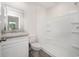 Bathroom with white vanity, matching toilet, and a shower-tub combo with built-in shelving at 230 Ashworth Dr., Tabor City, NC 28463