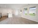 Open-concept living space with bright windows, wood-look flooring, and a view of the kitchen at 230 Ashworth Dr., Tabor City, NC 28463