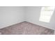 Simple bedroom with gray carpet, a window providing natural light, and neutral walls at 358 Jeff Waters Circle, Longs, SC 29568