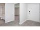 Hallway view showcasing bathroom access and a bedroom doorway with gray tone carpet at 358 Jeff Waters Circle, Longs, SC 29568