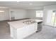 Modern kitchen includes an island with sink, stainless dishwasher, gray countertops, and plank flooring at 358 Jeff Waters Circle, Longs, SC 29568
