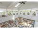 Light-filled sunroom with multiple windows, a ceiling fan, and colorful rug creating a cozy retreat at 340 Walden Lake Rd., Conway, SC 29526