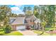 Front exterior view of brick home, lush green lawn, mature trees and attached two-car garage at 1296 Foxtail Dr., Longs, SC 29568