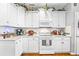 Well-lit kitchen with white cabinets, neutral countertops, and hardwood flooring at 1296 Foxtail Dr., Longs, SC 29568