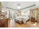 Serene main bedroom with hardwood floors, tray ceilings, and ensuite bathroom access at 1296 Foxtail Dr., Longs, SC 29568